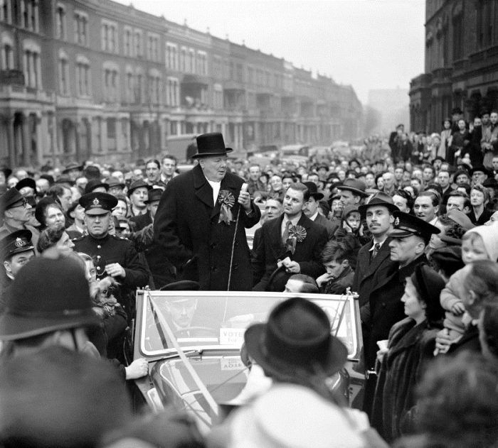 Sir Winston Churchill speaking from a car on the street in, Hammersmith, London to a crowd of people in 1949.